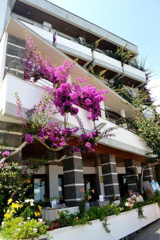 a building with purple flowers on the side of it at Hotel Cala Luna in Cala Gonone