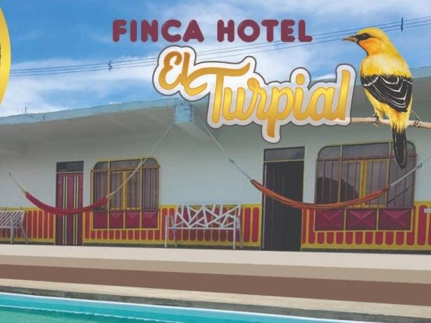 un pájaro sentado en un cartel frente a un hotel en FINCA HOTEL EL TURPIAL, en Quimbaya