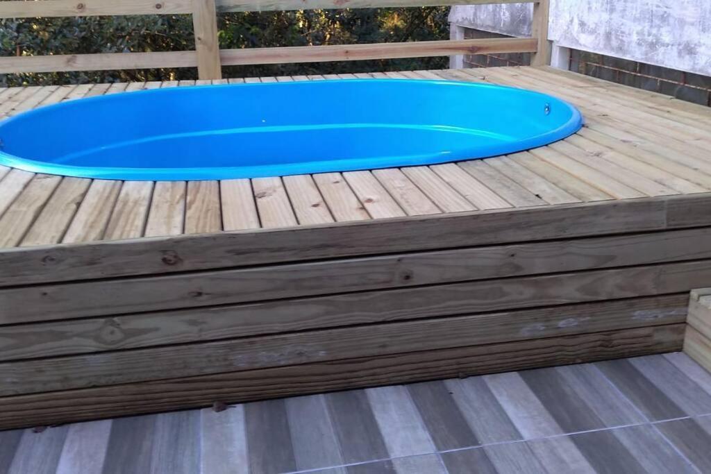 a pool on a wooden deck with a blue trampoline at Sobrado recanto som das águas in Santo Amaro da Imperatriz