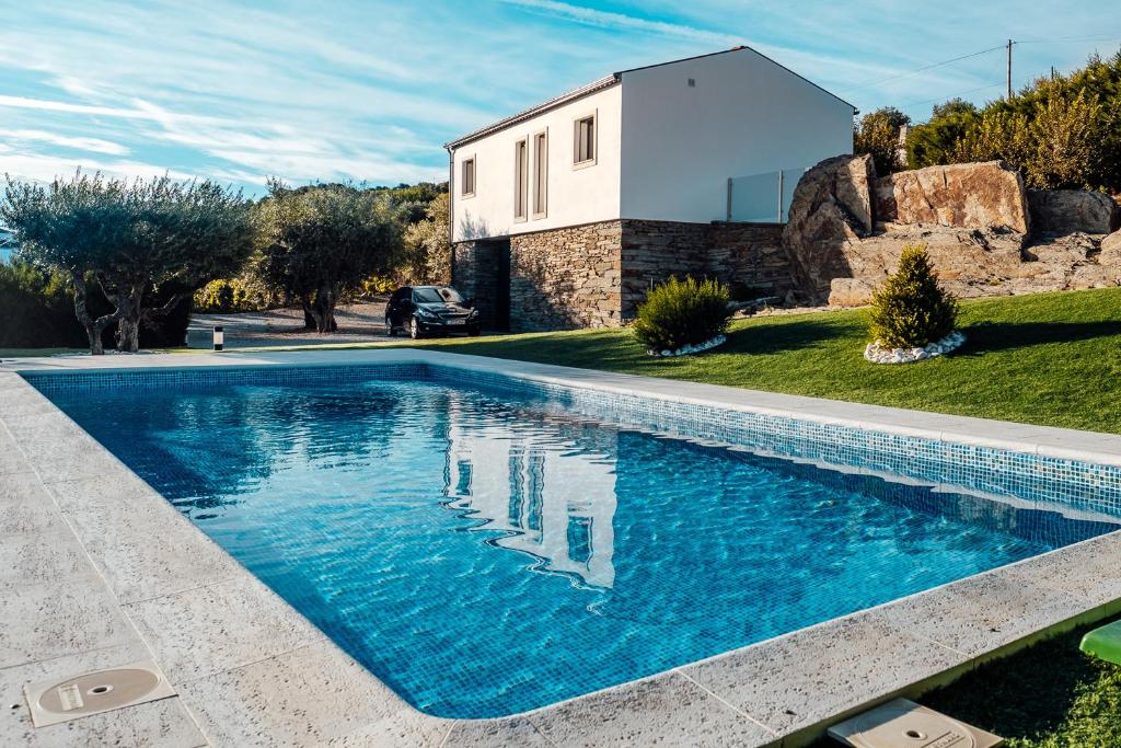 a swimming pool in front of a house at Domaine Casa Valença in Valença do Douro