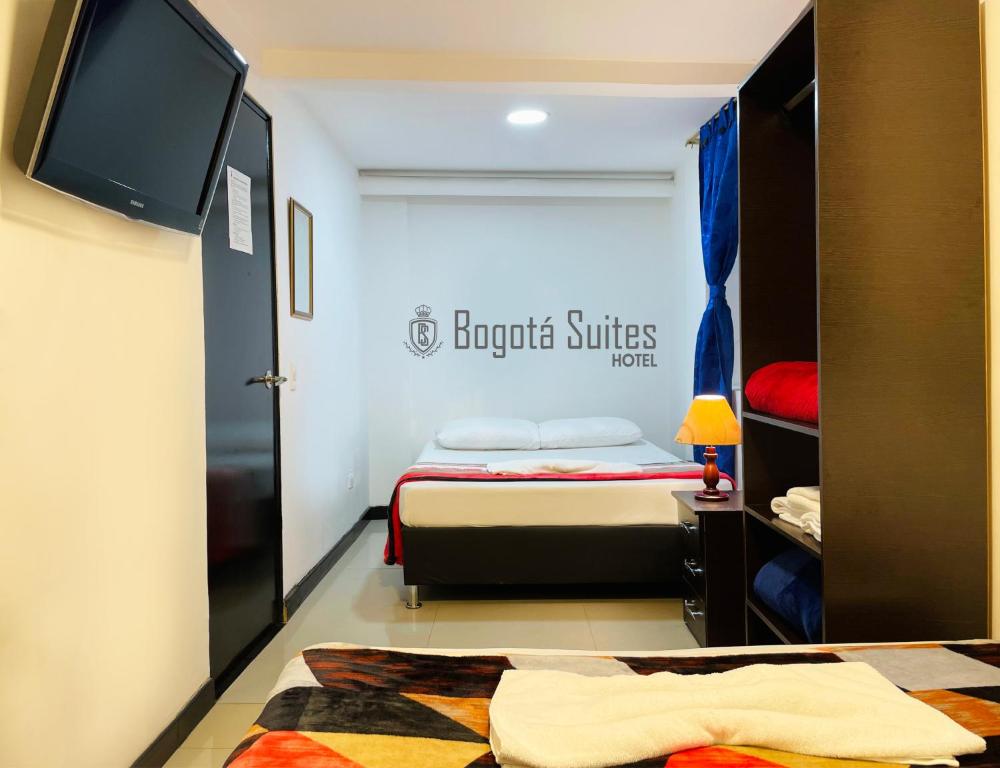 Habitación pequeña con cama y TV. en Hotel Bogotá Suites, en Bogotá