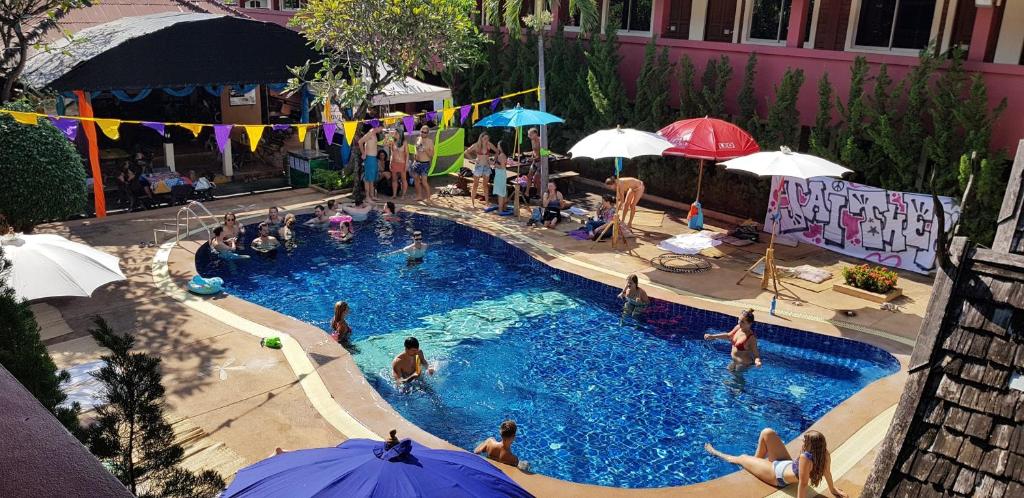 een groep mensen in een zwembad met parasols bij Red Brick in Chiang Mai