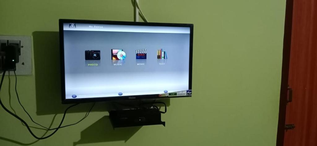 una TV a schermo piatto appesa a un muro di HILL VIEW HOTELS a Yelagiri
