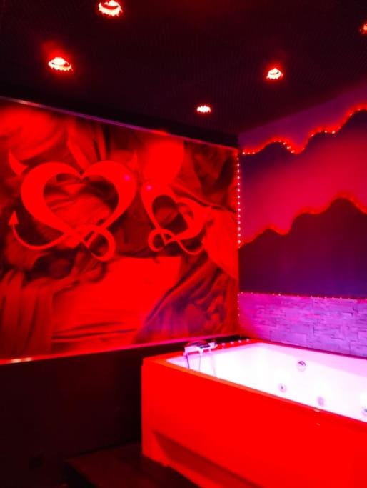 une chambre rouge avec un cœur peint sur le mur dans l'établissement la coquine, love room, romantique, à Toulon