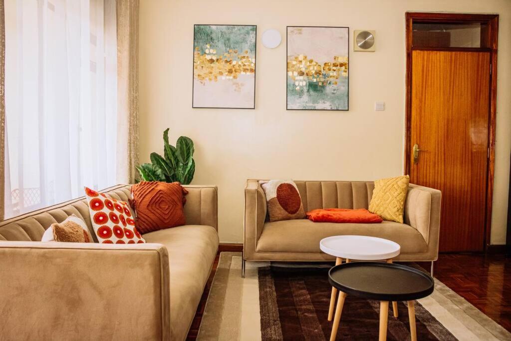 a living room with two couches and a table at The happy place - Westlands, Nairobi in Nairobi