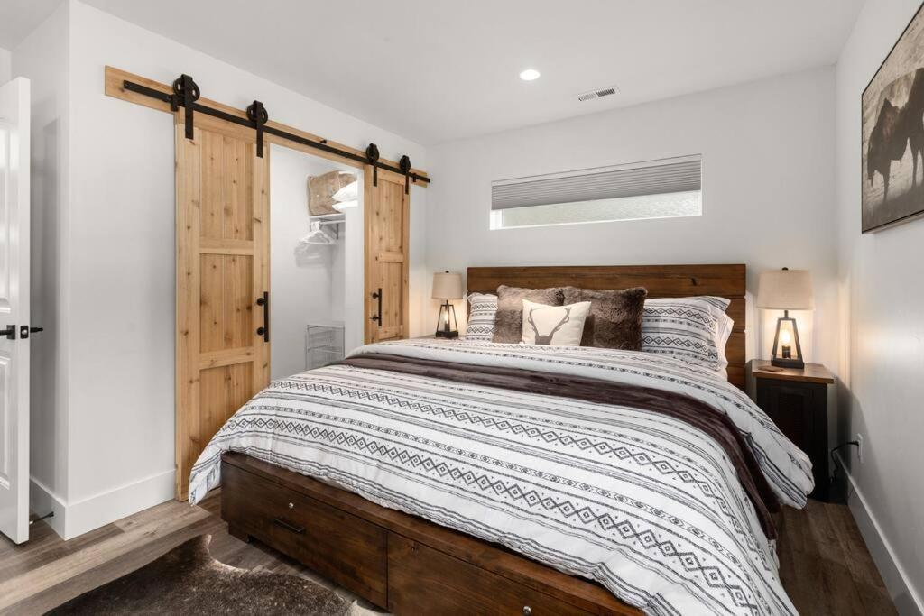 Schlafzimmer mit einem großen Bett mit einem Kopfteil aus Holz in der Unterkunft Mountain View Retreat at The Quarry - Sleeps 10! in Whitefish