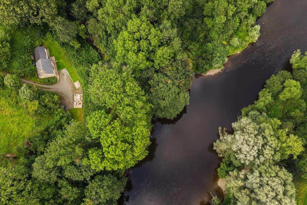 einem Luftblick auf einen Fluss inmitten eines Waldes in der Unterkunft Cabalva Mill Cottage - very private and with views over the River Wye in Clifford