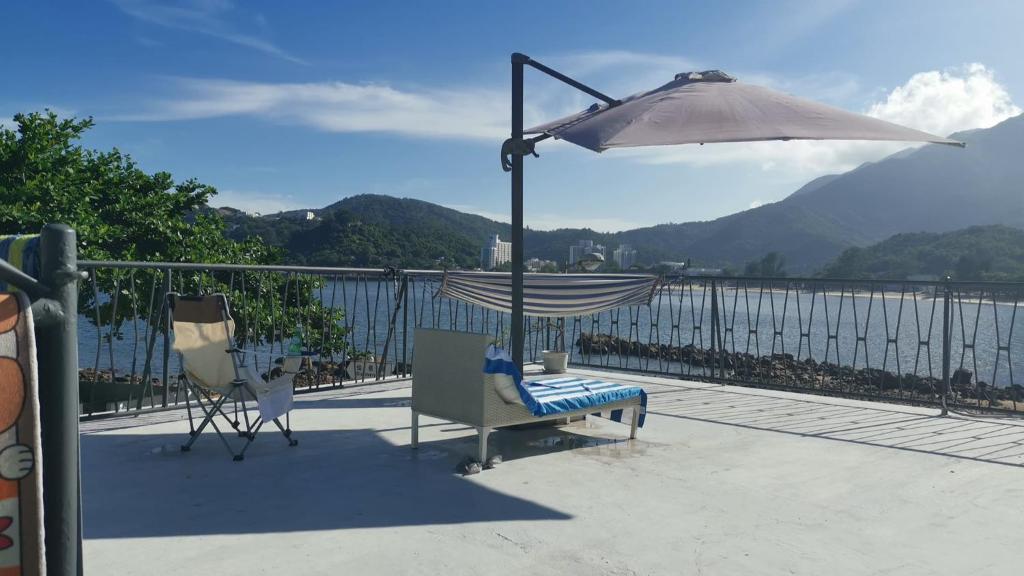 香港的住宿－A private room in beachside bungalow for women only，俯瞰水面的阳台配有吊床和遮阳伞