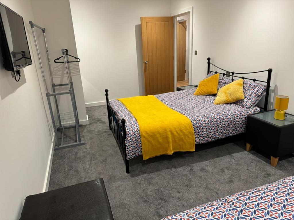 a bedroom with a bed with a yellow blanket at Bedroom 1 in Elegant 3 Bed Flat in Ramsgate in Kent