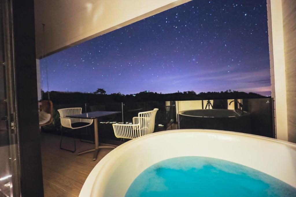eine Badewanne mit Blick auf den Nachthimmel in der Unterkunft Kirin Sky Resort in Khao Kho