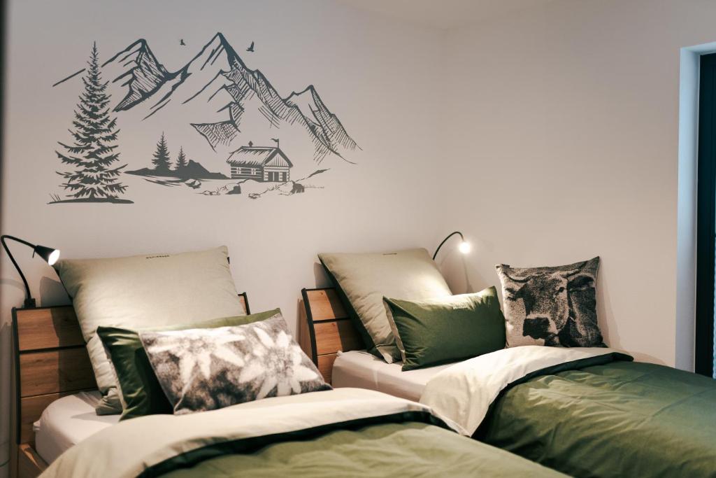 een slaapkamer met 2 bedden en een muurschildering van de bergen bij Chalets Woid_Liebe&Glück in Bodenmais