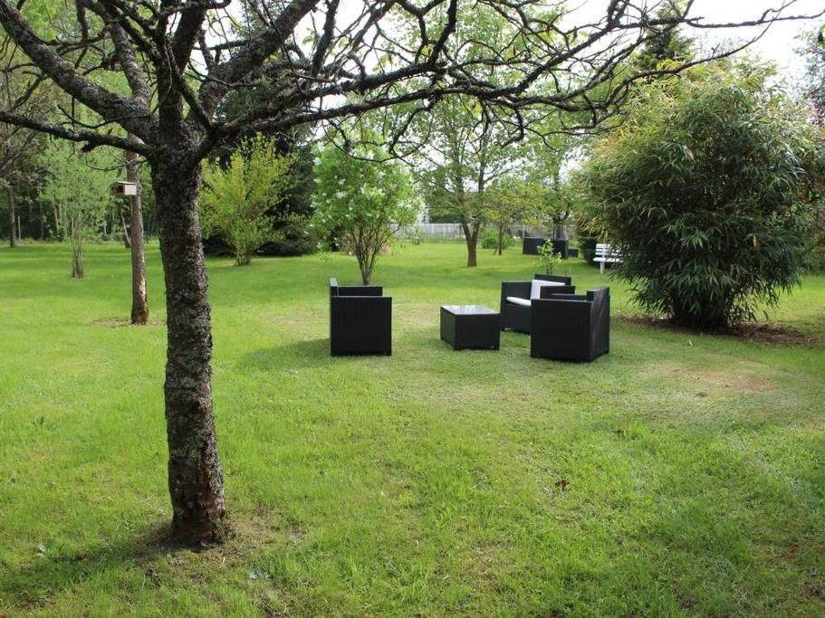un grupo de bancos sentados en un parque junto a un árbol en Domaine du parc en Grandvillers