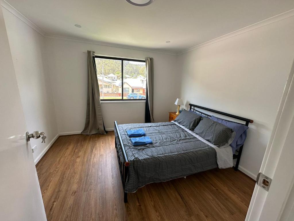 a bedroom with a bed and a large window at Peak View in Lithgow