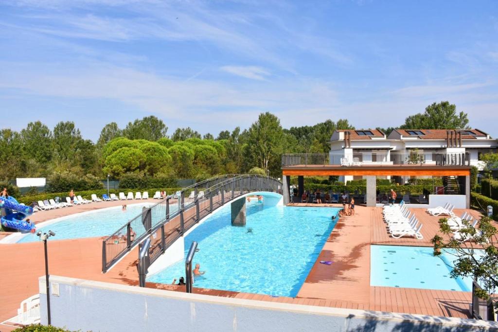una gran piscina con un puente sobre ella en Nice three bedroom apartment close to the sea, en Bibione