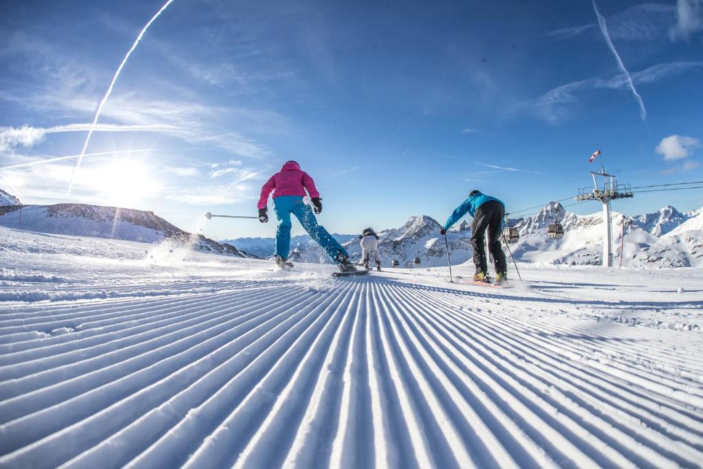 dos personas están esquiando por una pista cubierta de nieve en Ferienwohnung Sabine, en Flattach