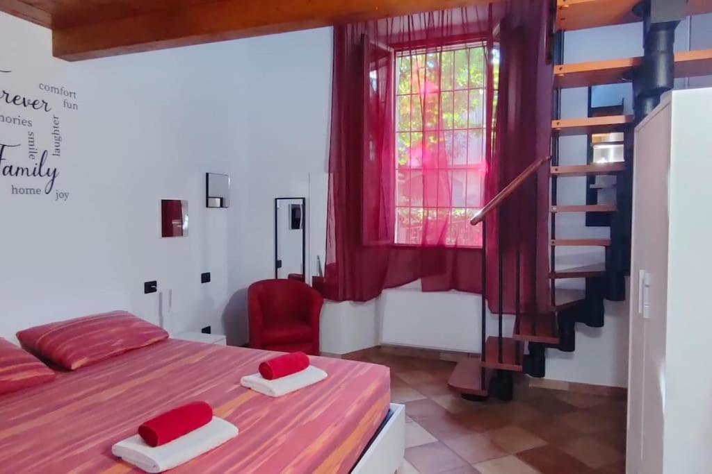 ein Schlafzimmer mit einem Bett und einem roten Stuhl in der Unterkunft la casa di trilly in Vigevano