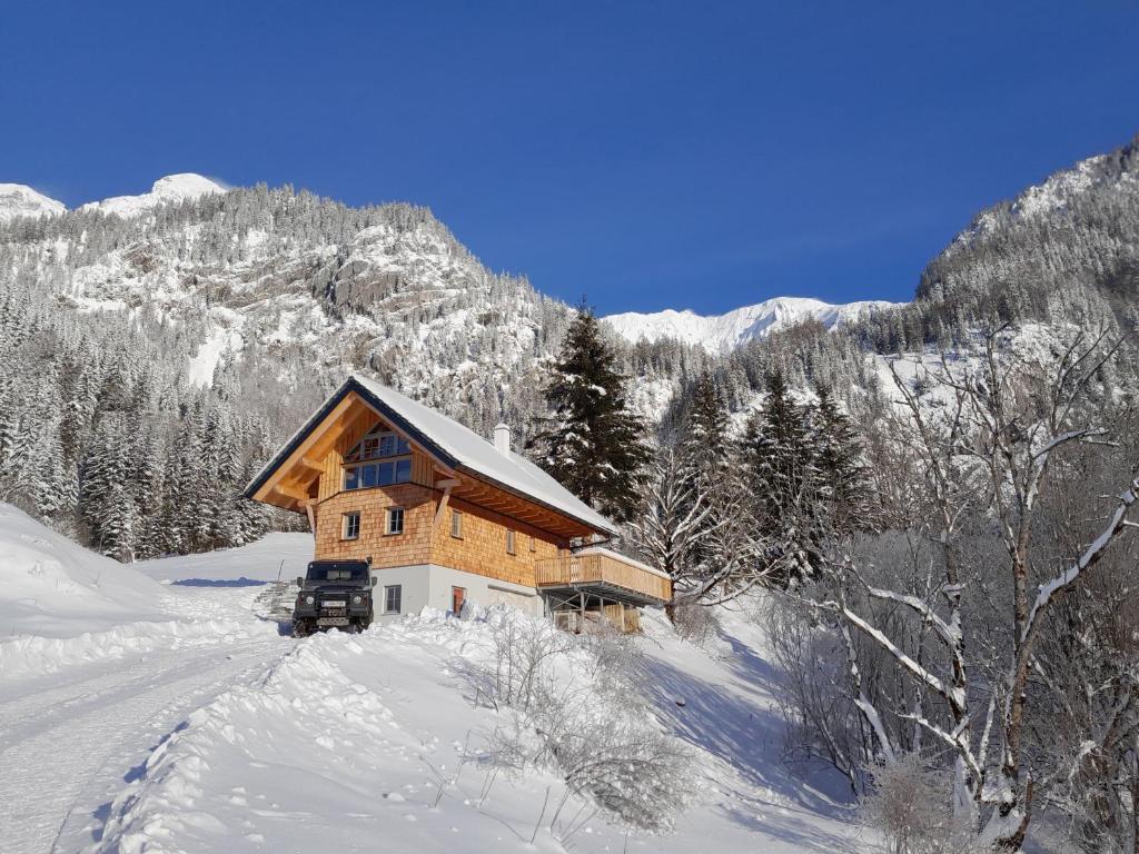 eine Holzhütte im Schnee in einem Berg in der Unterkunft Haus 1683 - Wolfbauer in Johnsbach