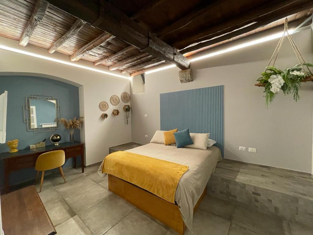 a bedroom with a bed and a desk and a mirror at La corte di Frascati in Frascati