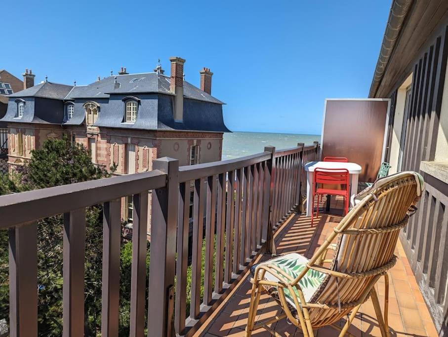 a chair sitting on a balcony overlooking the ocean at Les Sables d'Or - accès direct plage, vue mer, terrasses, parking in Houlgate