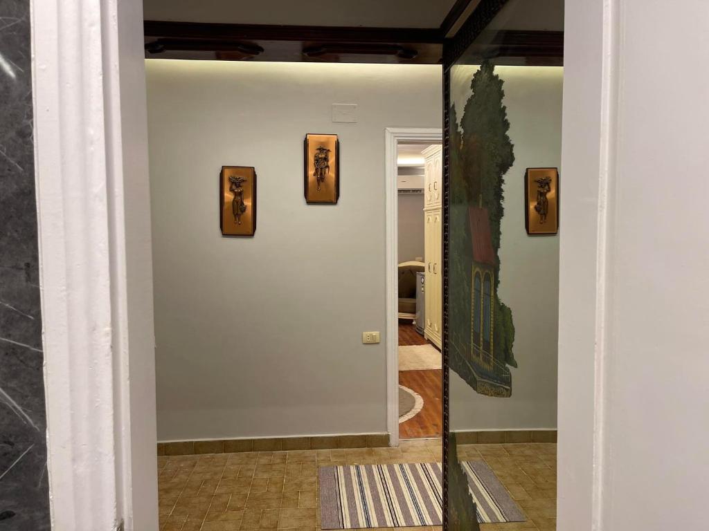 a mirror in a hallway with three pictures on the wall at المهندسين شقه سوبر لوكس - محى الدين ابو العز in Cairo