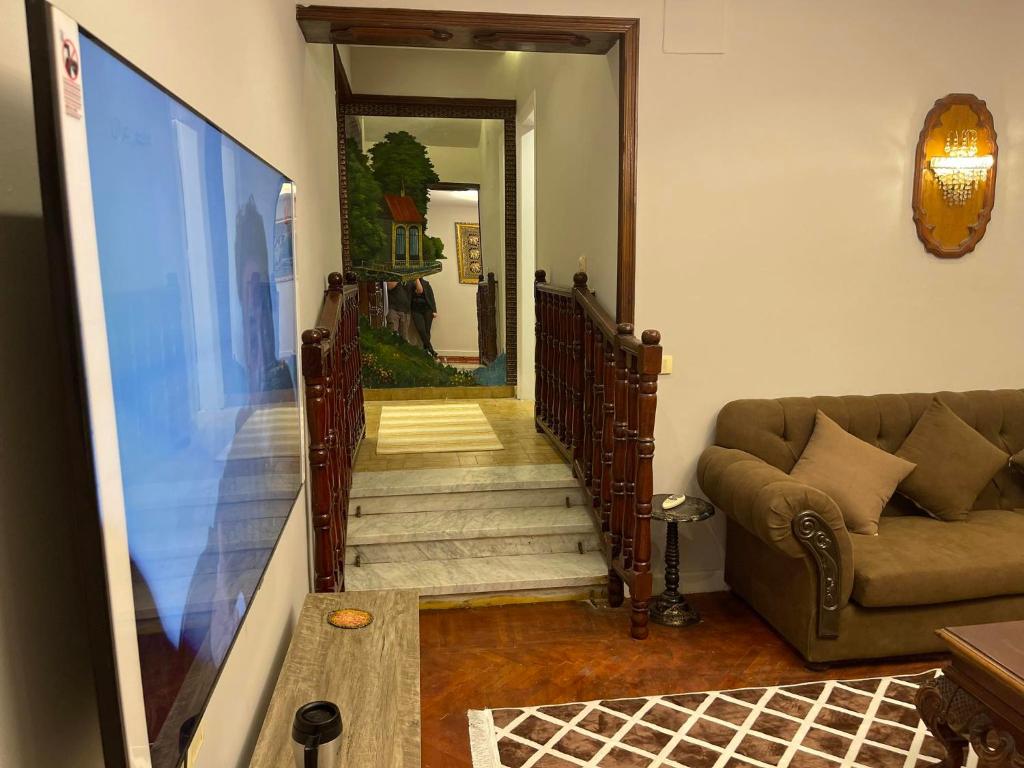 a living room with a couch and a stairway at المهندسين شقه سوبر لوكس - محى الدين ابو العز in Cairo