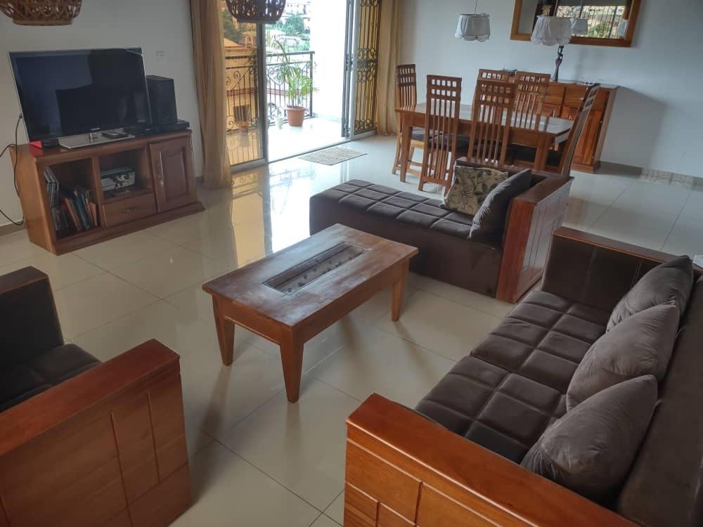 a living room with a couch and a coffee table at Appartement charmant logpom in Douala