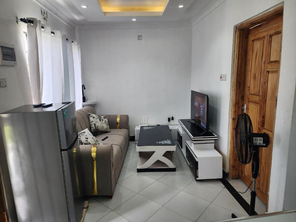 a living room with a couch and a tv at Swift Haven Studio Bamburi in Mombasa