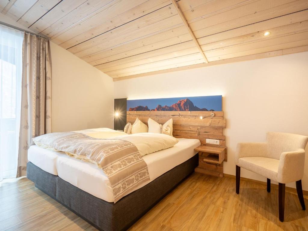 Schlafzimmer mit einem Bett, einem Schreibtisch und einem Stuhl in der Unterkunft Haus Mariandl in Nesselwängle