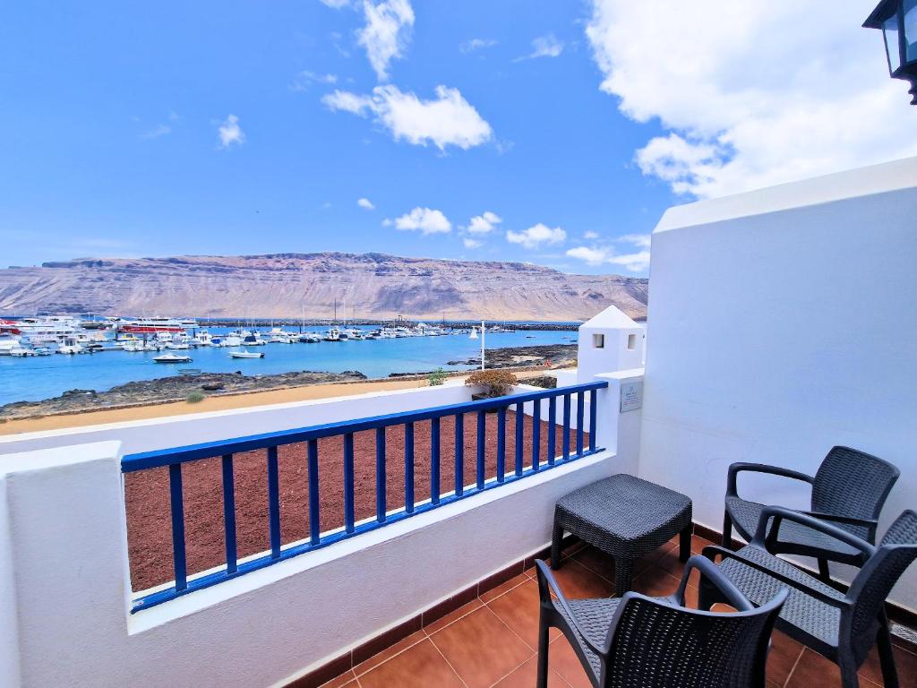 a balcony with chairs and a view of the marina at Aloe Vera Beach, Dúplex 1ª Línea de Mar in Caleta de Sebo