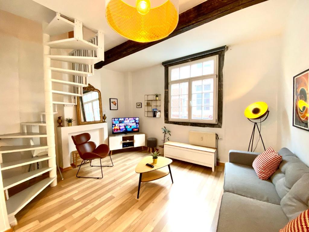 uma sala de estar com um sofá e uma mesa em Les Cerisiers - Duplex de Standing au Centre de Namur em Namur