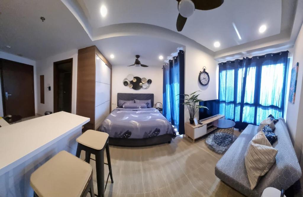 a bedroom with a bed and a couch and chairs at HarbourBay Residence. Batam. Studio. 1min to Ferry in Jodoh