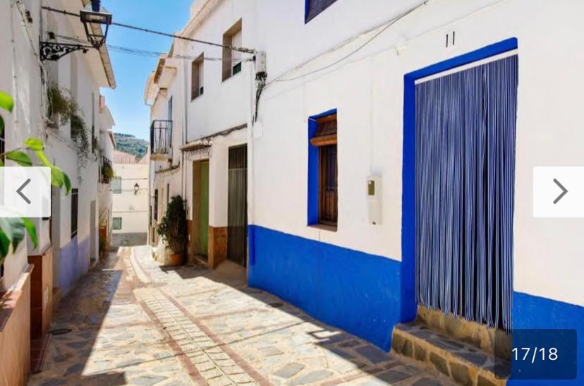Guájar FondónにあるCasa La Estrellaの青と白の建物とドアのある路地