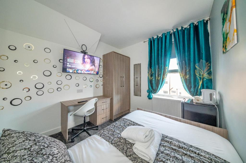 a bedroom with a bed and a tv on the wall at *Rb12s* For your most relaxed & Cosy stay + Free Parking + Free Fast WiFi * in Headingley