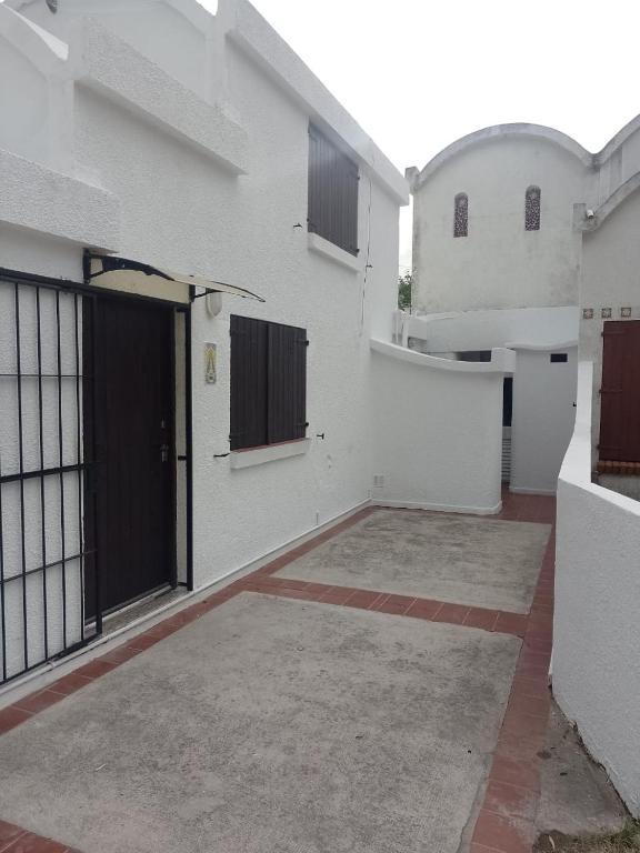 a white building with a gate and a door at Refugio Atlántico in San Bernardo