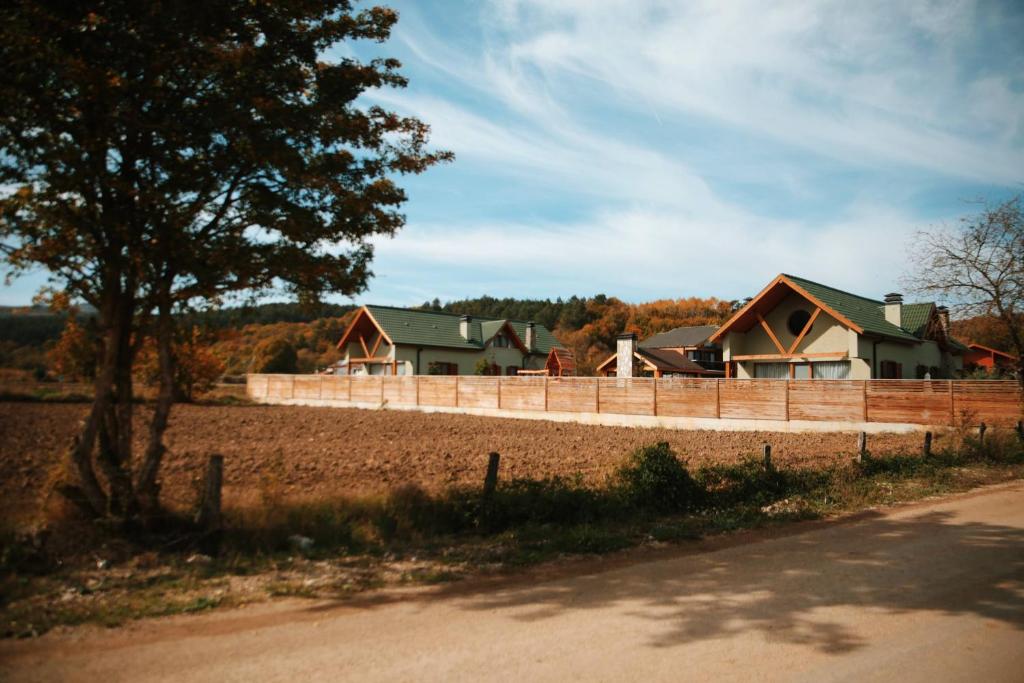 a fence in front of a farm with houses at Abant Cozy Homes in Bolu