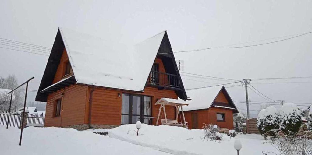 クルシュコフツェにあるDomek w górachの屋根に雪が積もった木造家屋
