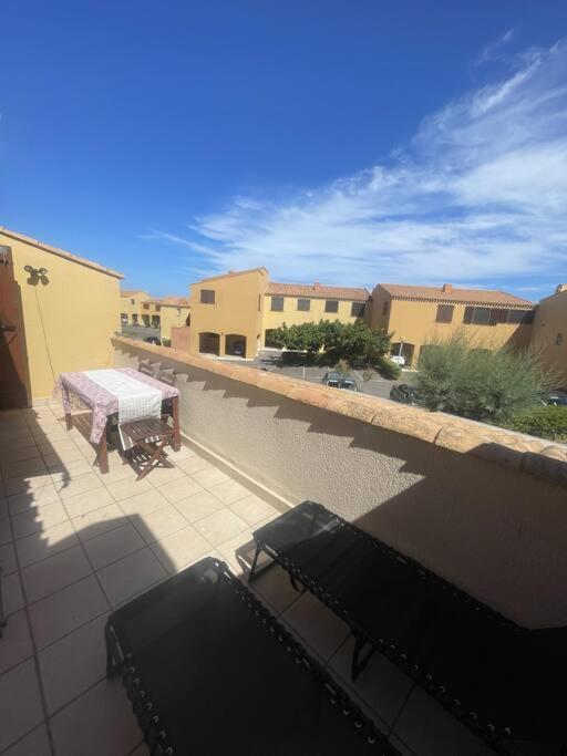 d'une terrasse avec une table et des bancs sur un balcon. dans l'établissement T2 Cap d'Agde bord Roquille, au Cap d'Agde