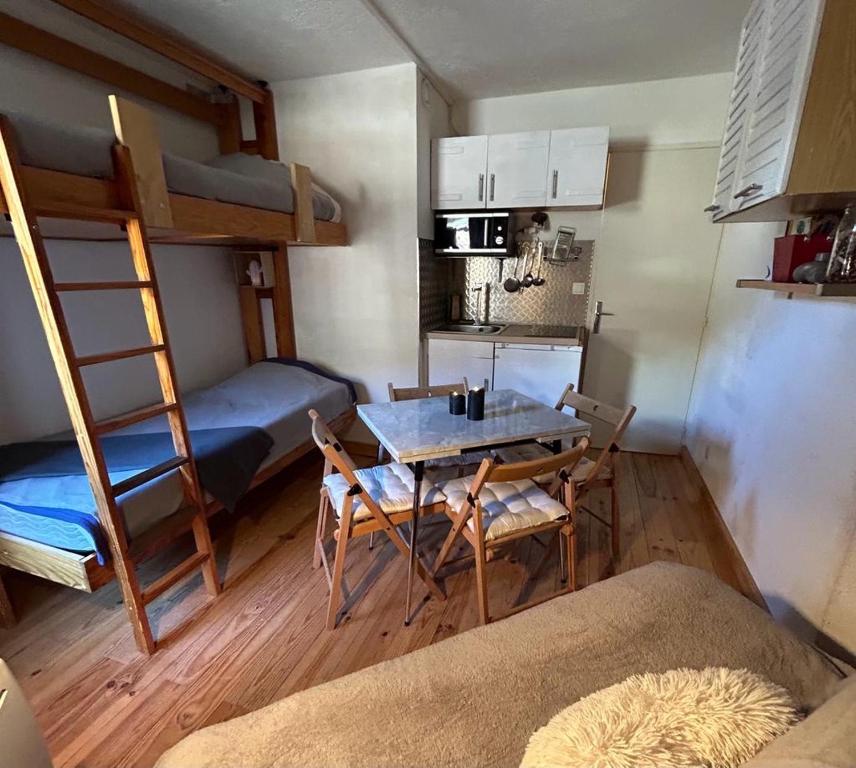 a small room with a table and a bunk bed at appartement à la Foux d'Allos in La Foux