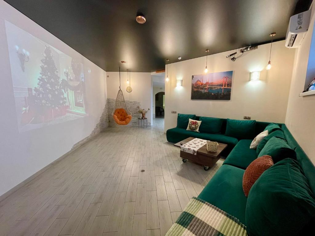 ein Wohnzimmer mit einer grünen Couch und einem Weihnachtsbaum in der Unterkunft Апартаменти Underground&SPA in Lwiw