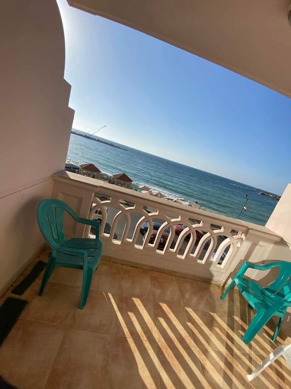 2 sillas verdes en una habitación con vistas al océano en Sidi bishr sea view, en Alejandría