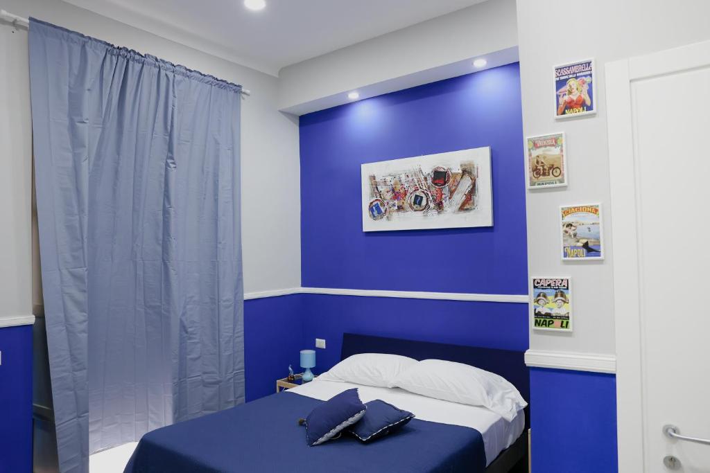 ein blaues Schlafzimmer mit einem Bett mit blauer Wand in der Unterkunft Concept b&b naples in Neapel