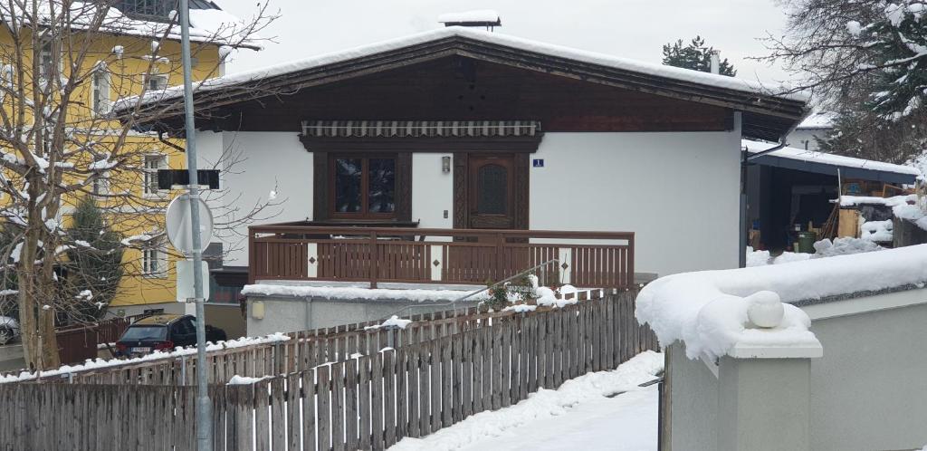 ein Haus mit einem Holzzaun im Schnee in der Unterkunft Ferienwohnung Singer in Völs