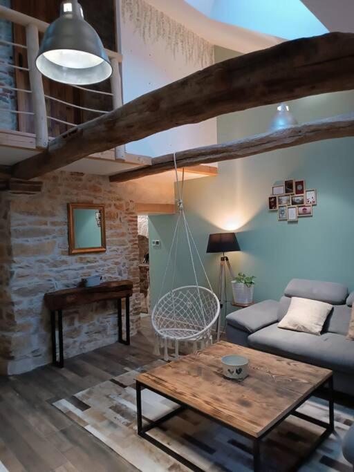un salon avec un canapé et une table dans l'établissement Maison authentique au pieds du vignoble de 135m2 6 personnes, à La Charme