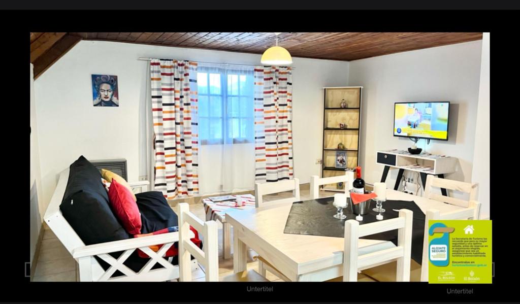 a living room with a table and chairs and a television at ApartamentsLouis in El Bolsón