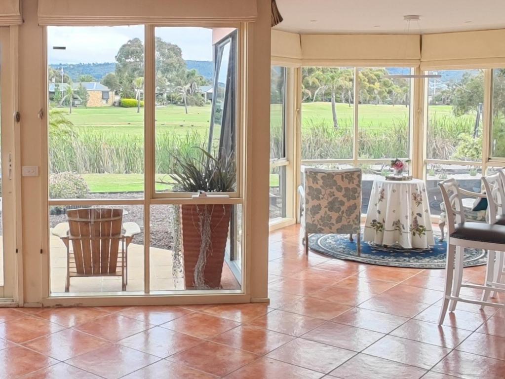 a screened in porch with a table and chairs at Golf Spa Retreat in Safety Beach