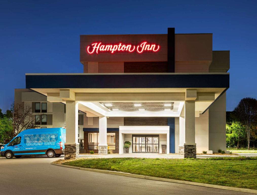 a hampton inn with a van parked outside of it at Hampton Inn Kansas City - Airport in Kansas City