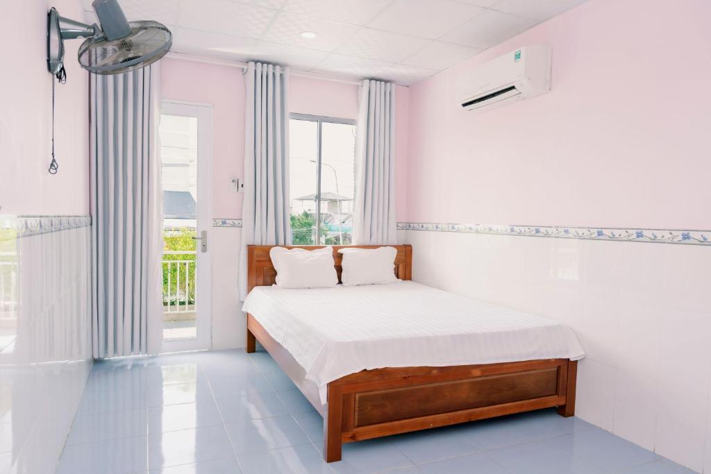 Habitación blanca con cama y ventana en Phương Tú Hostel en Xuyên Mộc