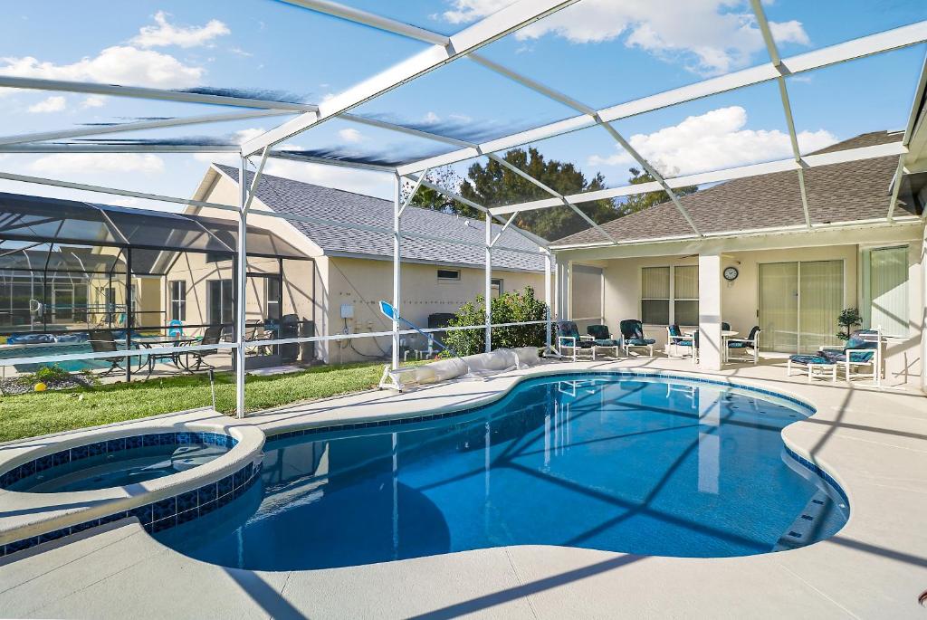 een zwembad met een pergola en een huis bij Grand Exclusive 4BR Pool Home near Disney Parks in Davenport