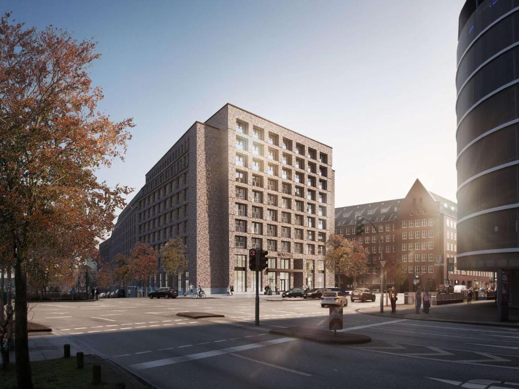 ein hohes Gebäude in einer Stadtstraße mit einem Gebäude in der Unterkunft Novotel Hamburg Central Station in Hamburg