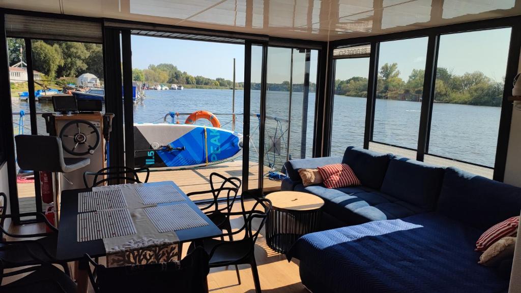 ein Wohnzimmer auf einem Boot mit einer blauen Couch in der Unterkunft Houseboat Water King apartament pływający dom na wodzie łódź Hausboot 7 os in Uraz
